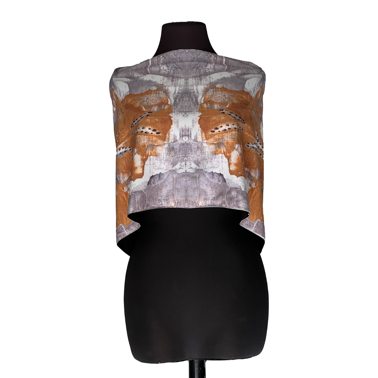 Abstract orange-and-white patterned sleeveless top on a black mannequin