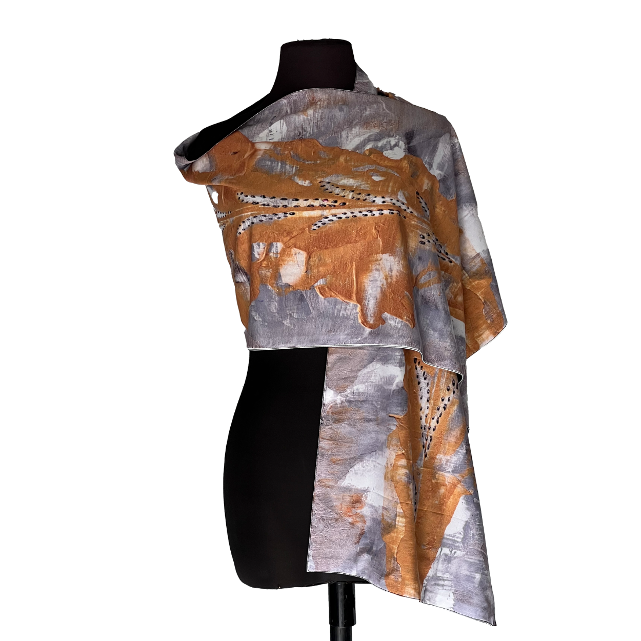 Abstract orange, gray, and white asymmetrical top on a black mannequin