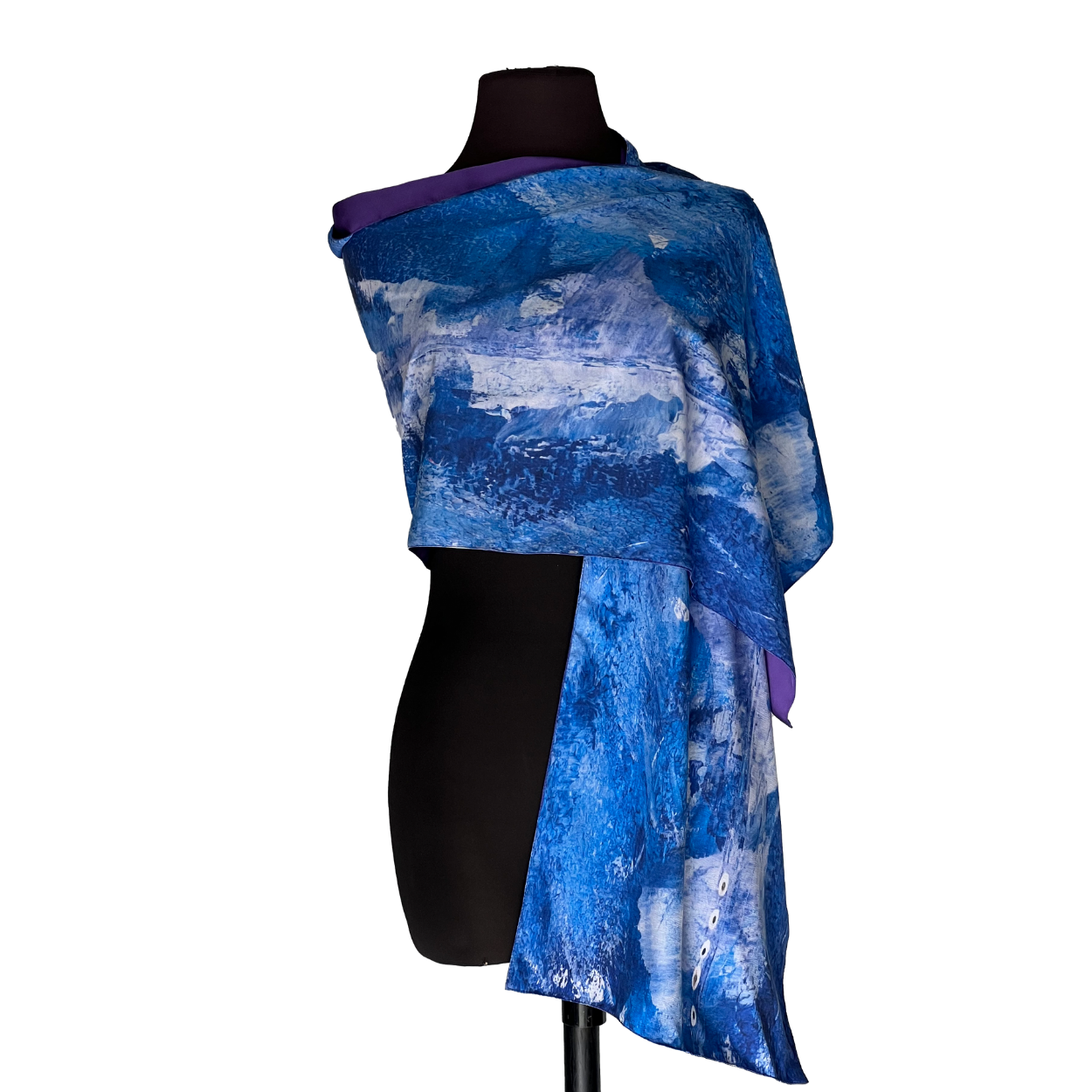 Blue patterned shawl draped over a black mannequin on a white background
