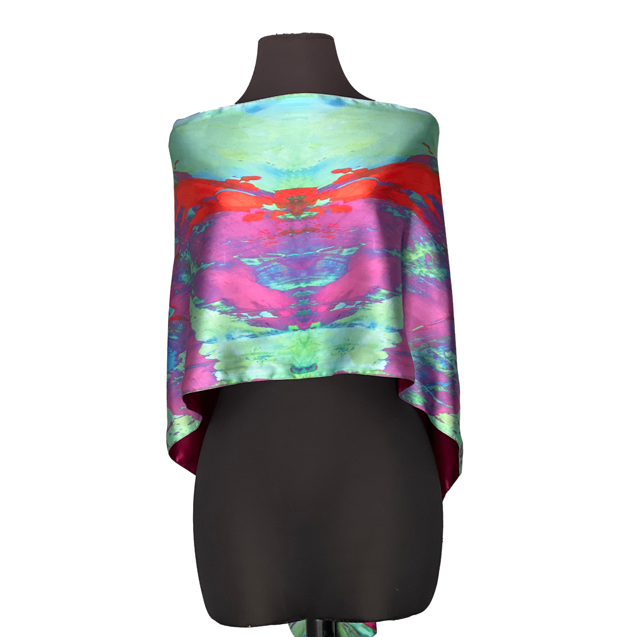 Silk scarf on a black mannequin, with a tie-dye pattern in red, pink, blue, and green.