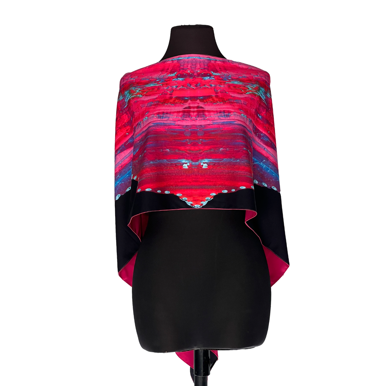 Pink and red patterned shawl draped over a black dress form mannequin