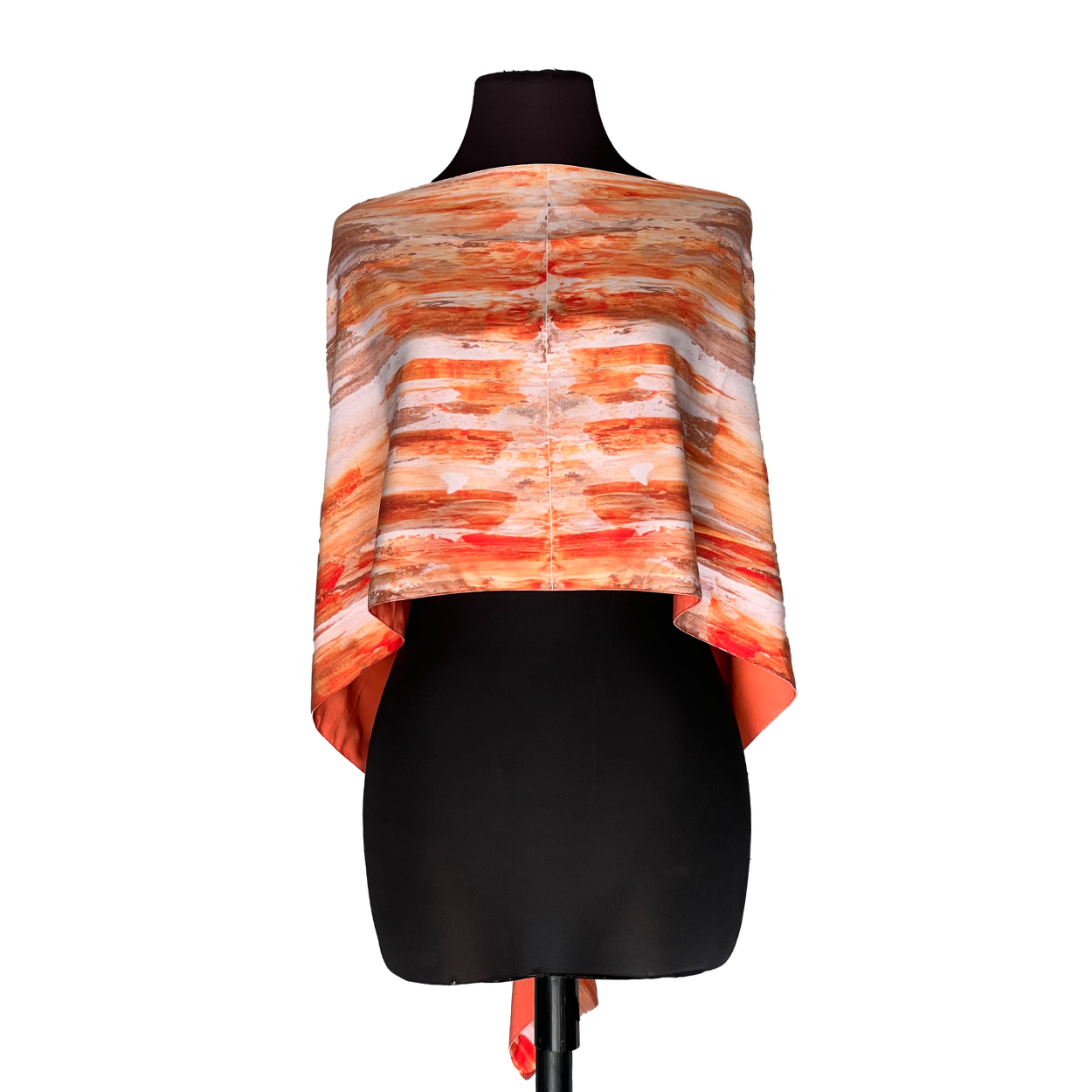 Black mannequin wearing an orange-and-white striped asymmetrical shawl dress
