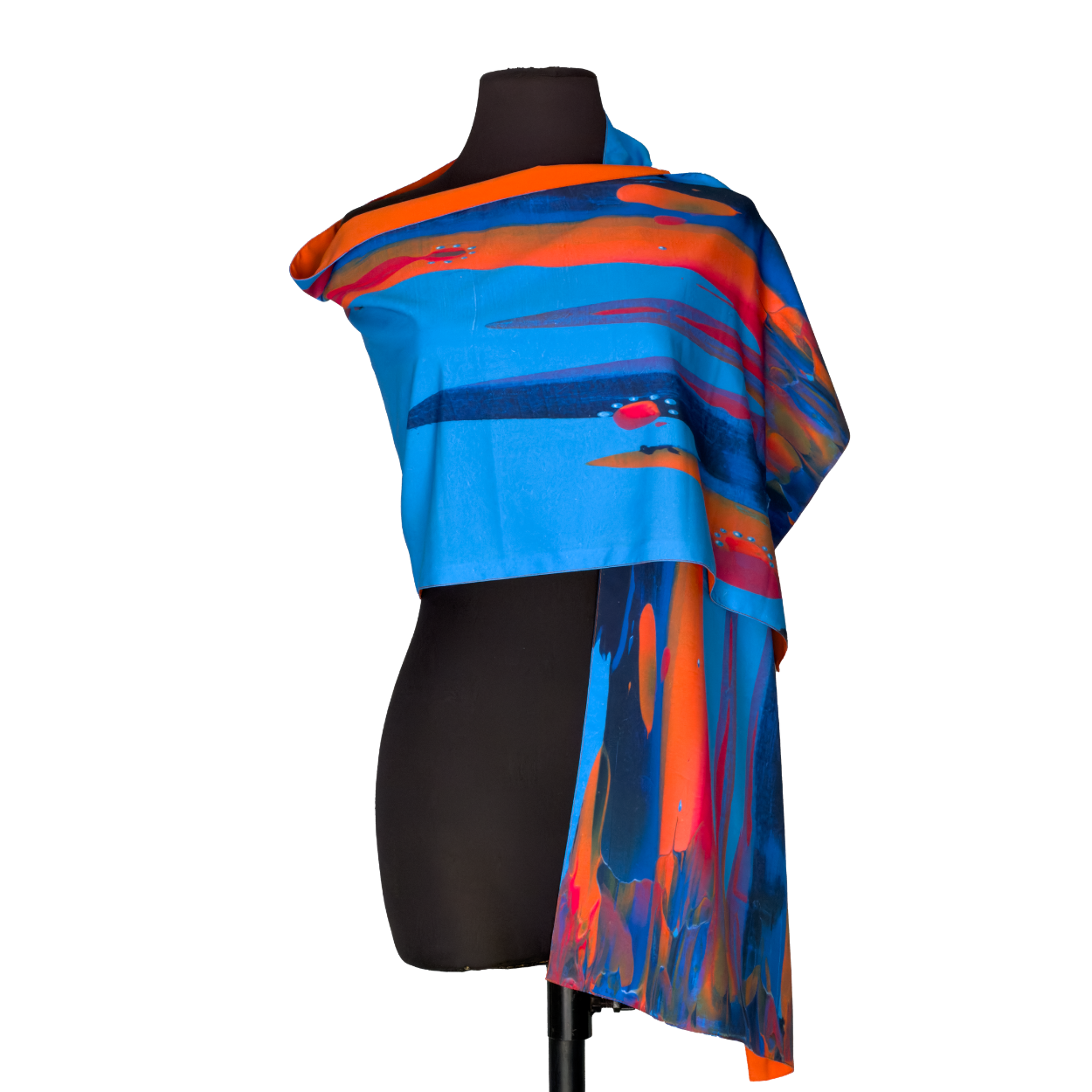 Black mannequin wearing a bright blue and orange abstract shawl and draped scarf