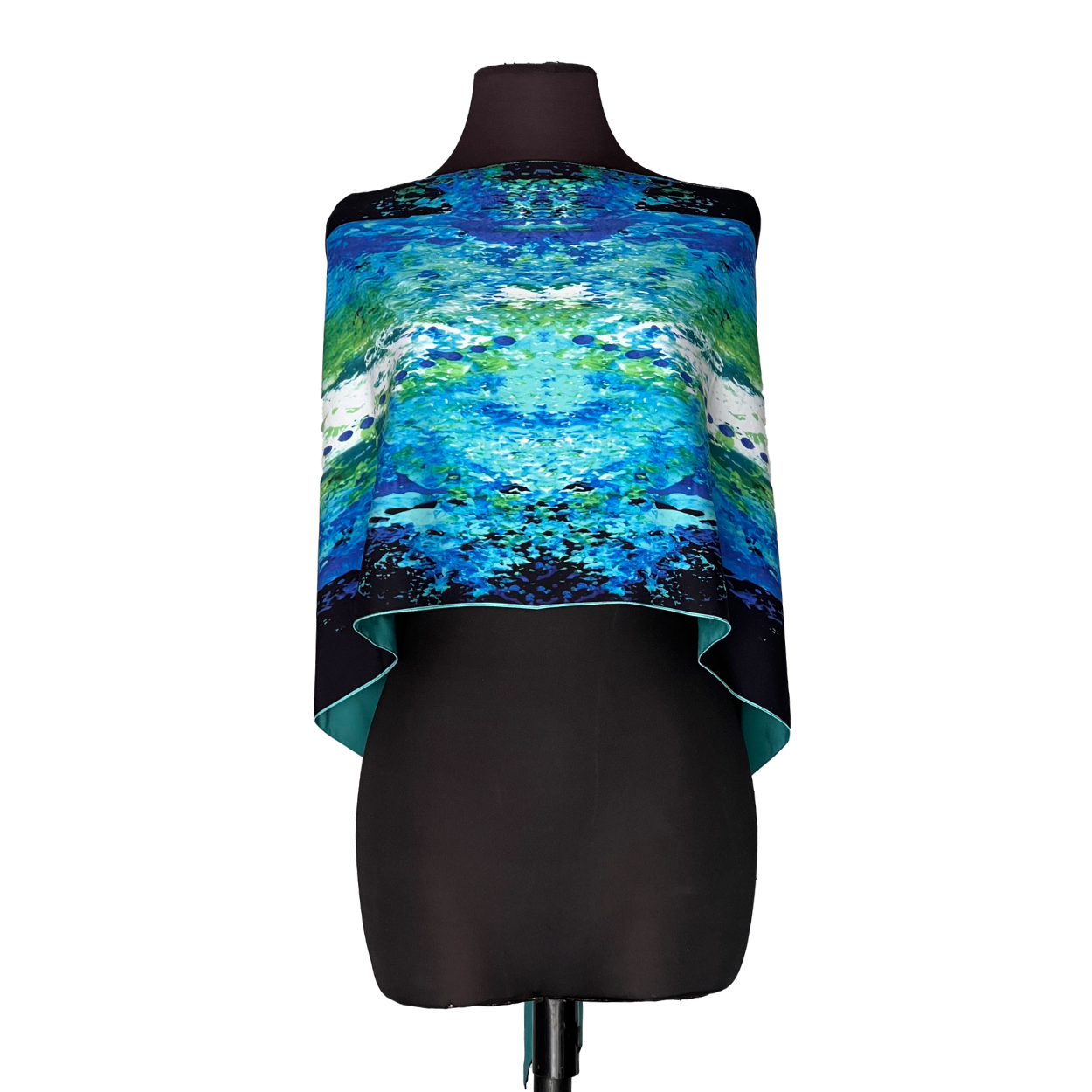 Colorful blue-green abstract shawl draped over a black dress form mannequin