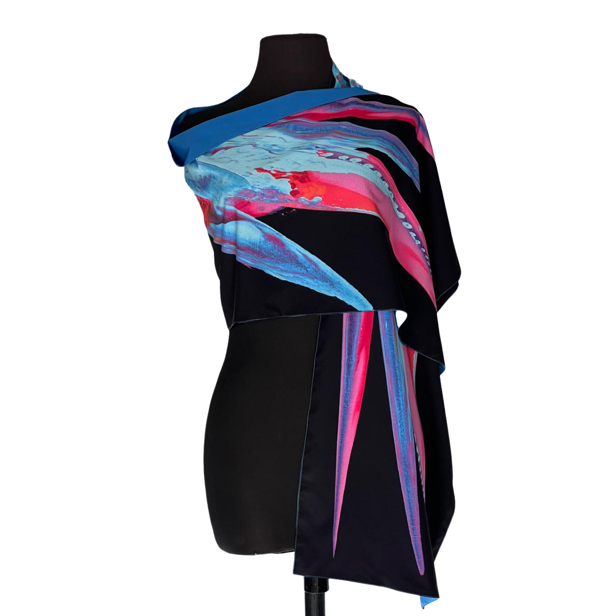 Black mannequin wearing a vibrant blue, pink, and black asymmetrical scarf-like dress on white background