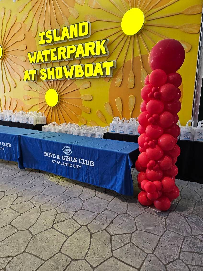 Red balloon column by My Life In Balloons LLC for the Let’s Get Cookin’ 2024 event at Island Waterpark, Showboat Atlantic City. Positioned next to Boys & Girls Club tables.