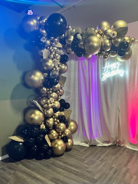 Black and gold organic balloon garland with floral and metallic leaf accents by My Life In Balloons LLC, created for an elegant 50th birthday celebration.
