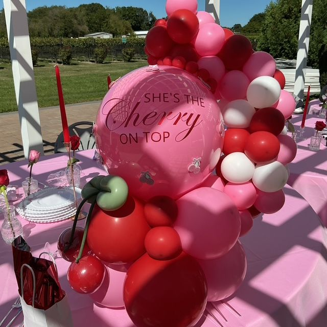 “She’s the Cherry on Top” balloon bouquet centerpiece with red, pink, and white balloons, custom cherry accents, and printed balloon centerpiece by My Life In Balloons LLC at The Blue Cork Winery in Williamstown, NJ.