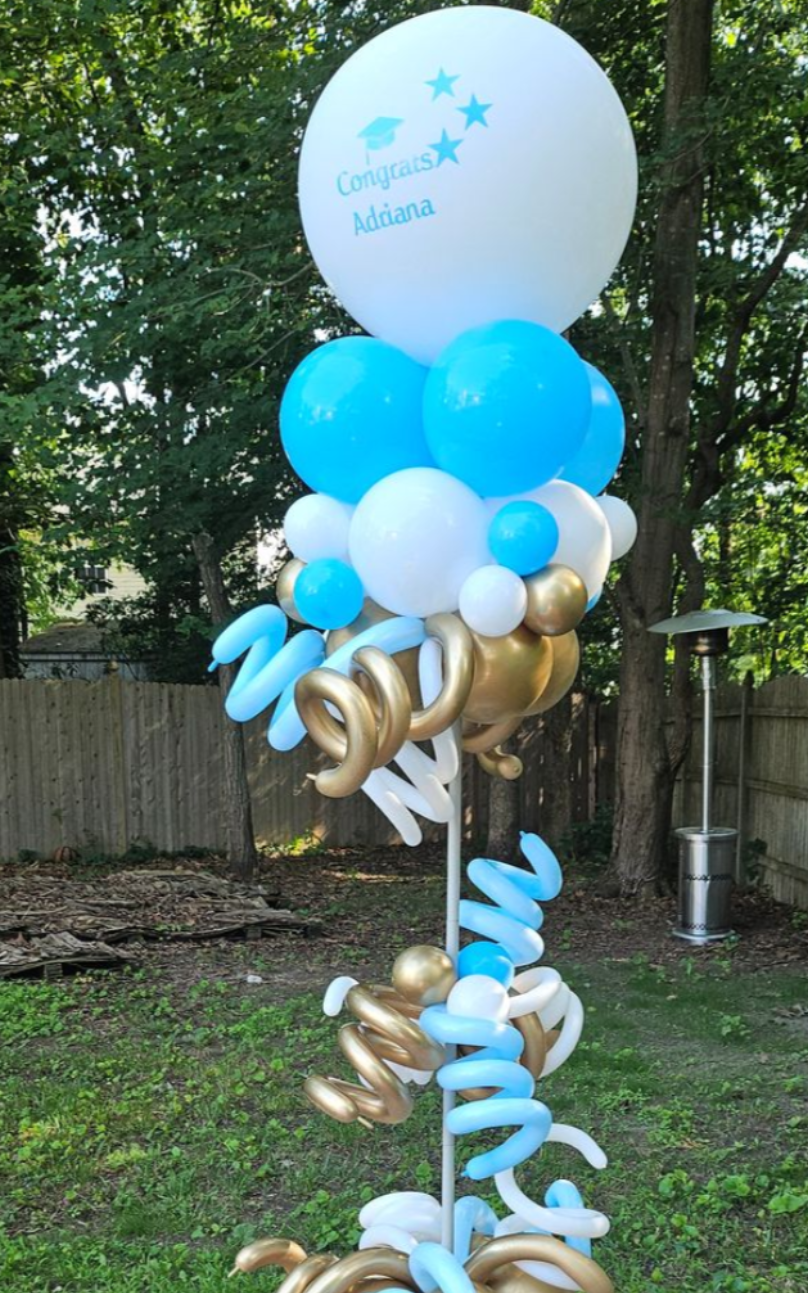 Blue, white, and gold balloon circle arch with “Congrats Grad” sign and backdrop by My Life In Balloons LLC for a graduation celebration.
