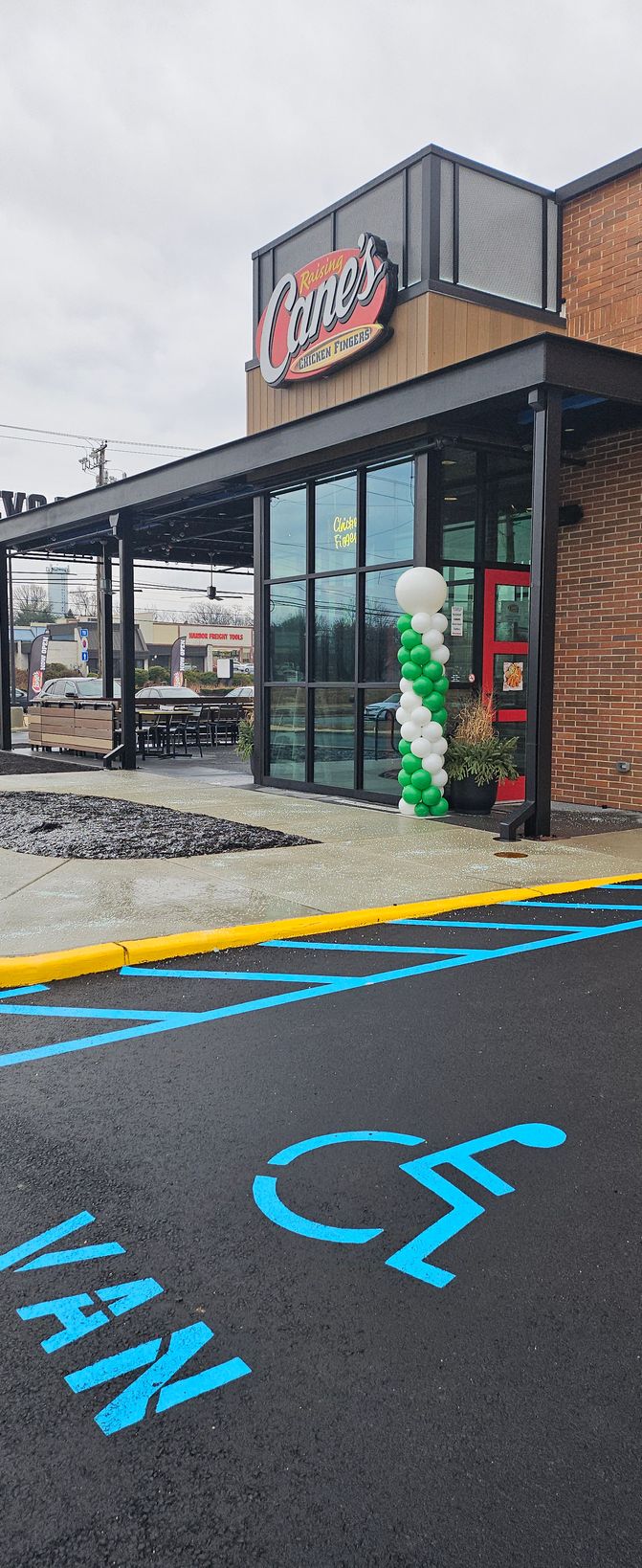 Green and white balloon column created by My Life In Balloons LLC for Raising Cane’s Super Bowl brand activation, celebrating the Philadelphia Eagles outside the restaurant entrance.