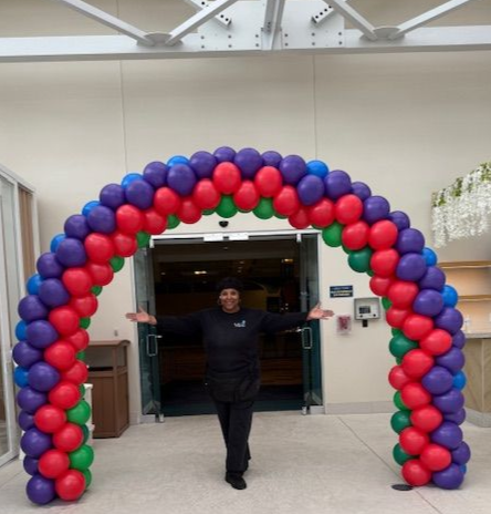 Multicolored balloon arch featuring red, green, purple, and blue balloons by My Life In Balloons LLC at Showboat for Let’s Get Cookin’ 2025.
Title Tag: