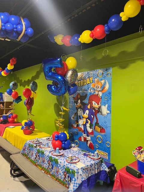 Sonic the Hedgehog birthday decor at Fun City in Turnersville, NJ with balloon ceiling garland, number 5 foil balloon, and character poster.