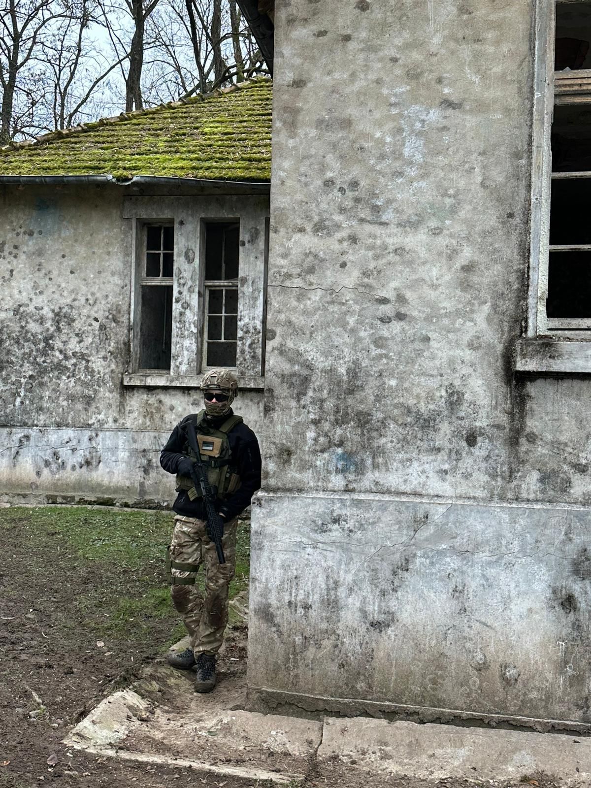 Ein Mann in Militäruniform steht vor einem alten Gebäude.