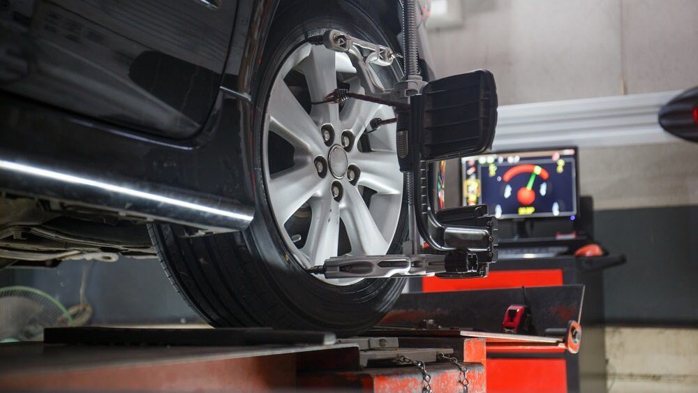 A Car Is Being Aligned with A Machine in A Garage — Tweed Exhaust & Mechanical In Tweed Heads South, NSW