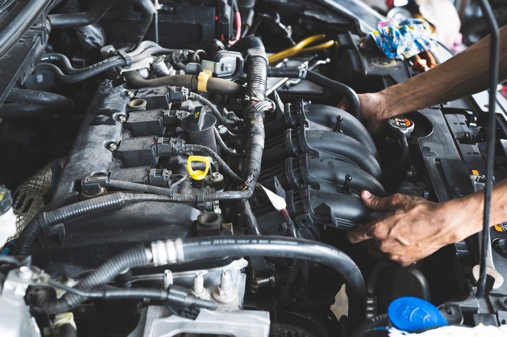A Man Is Working on The Engine of A Car — Tweed Exhaust & Mechanical In Tweed Heads South, NSW