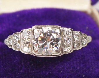 Vintage diamond engagement ring with a stepped design at the sides.