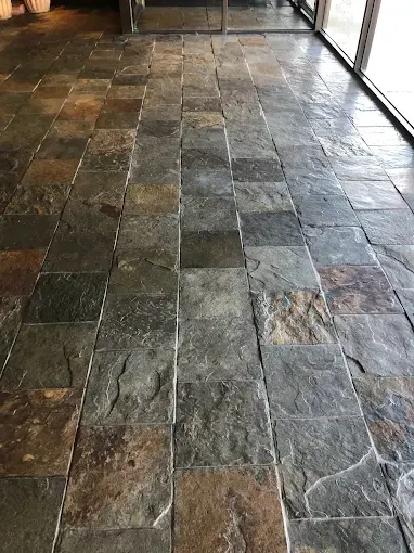 Slate tile floor, various shades of gray, brown, and tan, in a building.