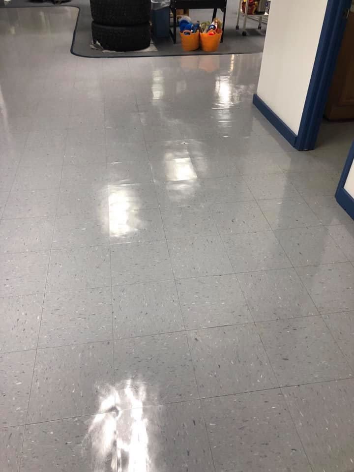 Gray floor with bright light reflections; tires and bins are in the background.