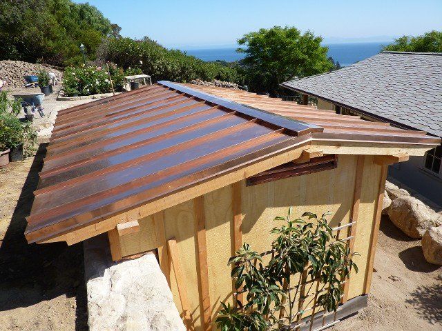 Copper roof on a wooden structure, ocean in the background. Sunny day.
