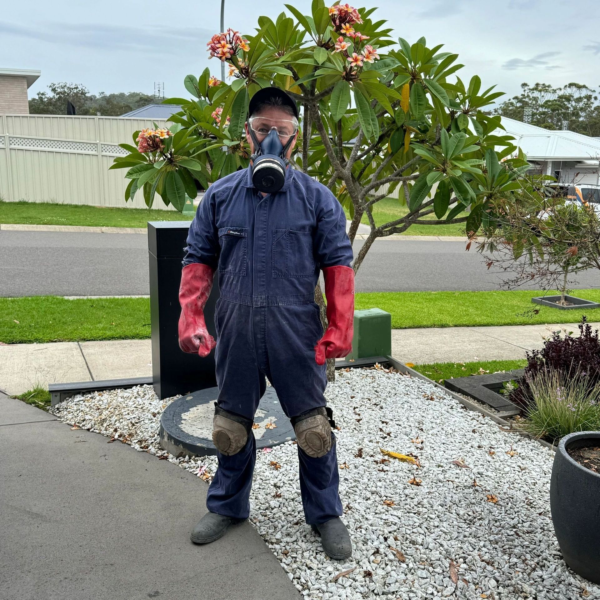 Pest Control Technician in respirator, coveralls, gloves, and knee pads — Hancock Pest Control in Mardi, NSW