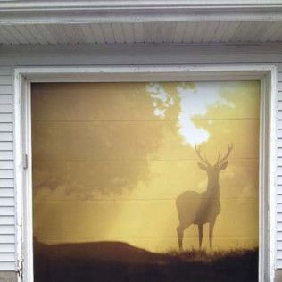 Garage door with deer silhouette against a sunset.