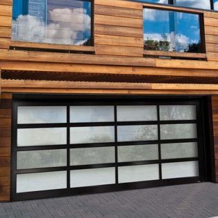 A modern garage door with a wooden building in the background