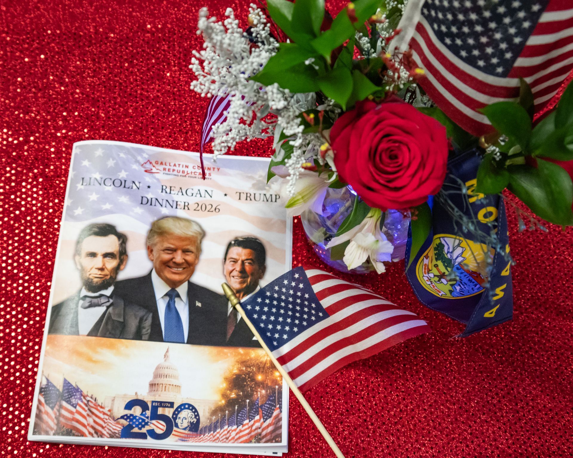 Trump-themed card with U.S. flags and a red rose on a glittery red background