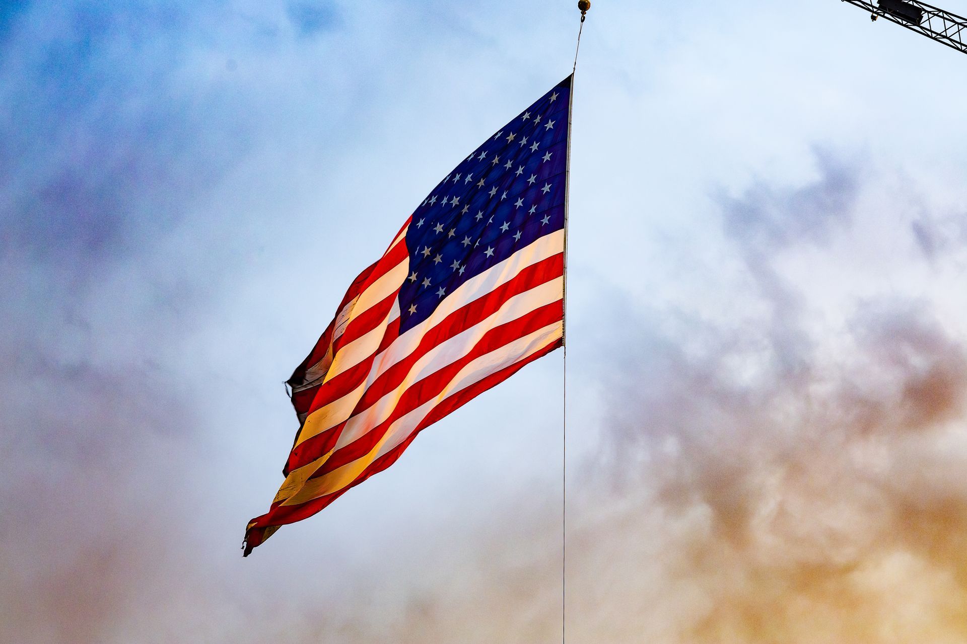 American flag waving against a cloudy sky