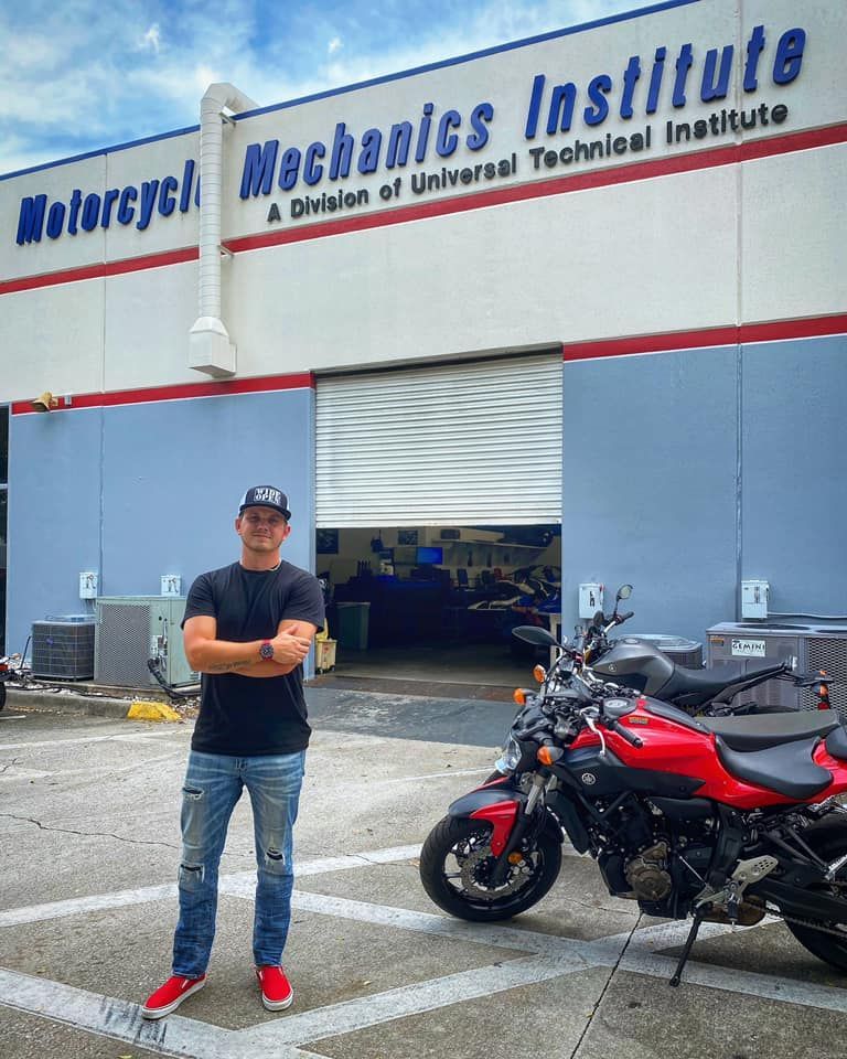 A man is standing beside a motorcycle — St. Augustine, FL — Wide Open Mobile Tech