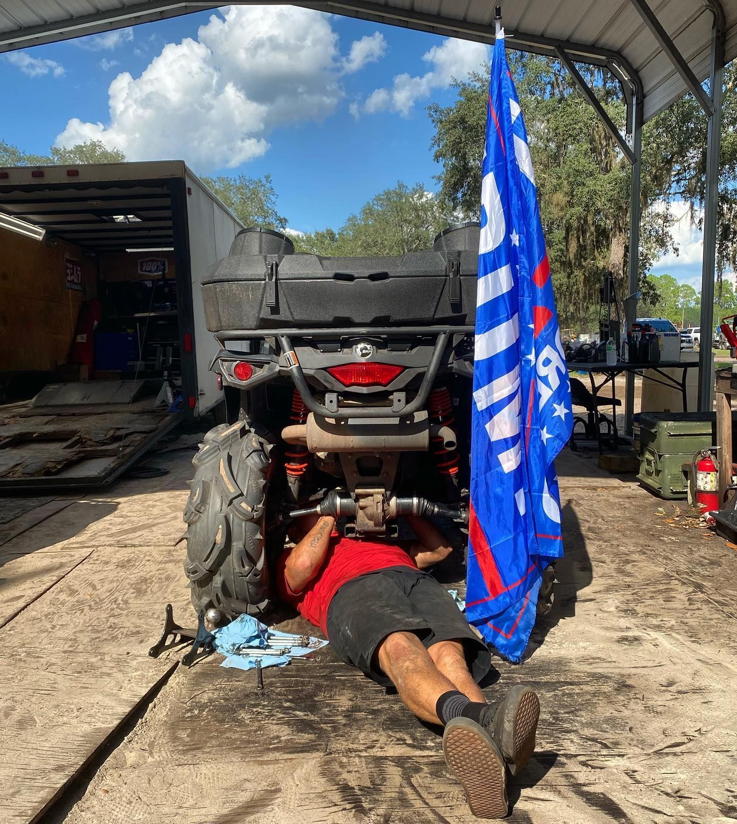 A man is lying on the ground working on an ATV — St. Augustine, FL — Wide Open Mobile Tech