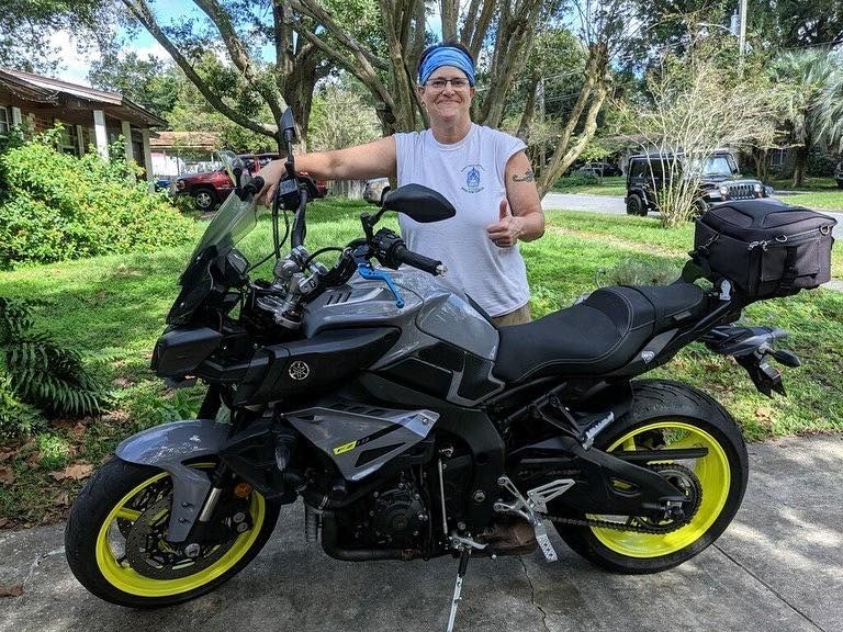 A man is standing next to a motorcycle on a sidewalk — St. Augustine, FL — Wide Open Mobile Tech