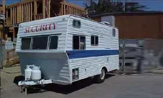 A security trailer is parked in front of a building under construction.