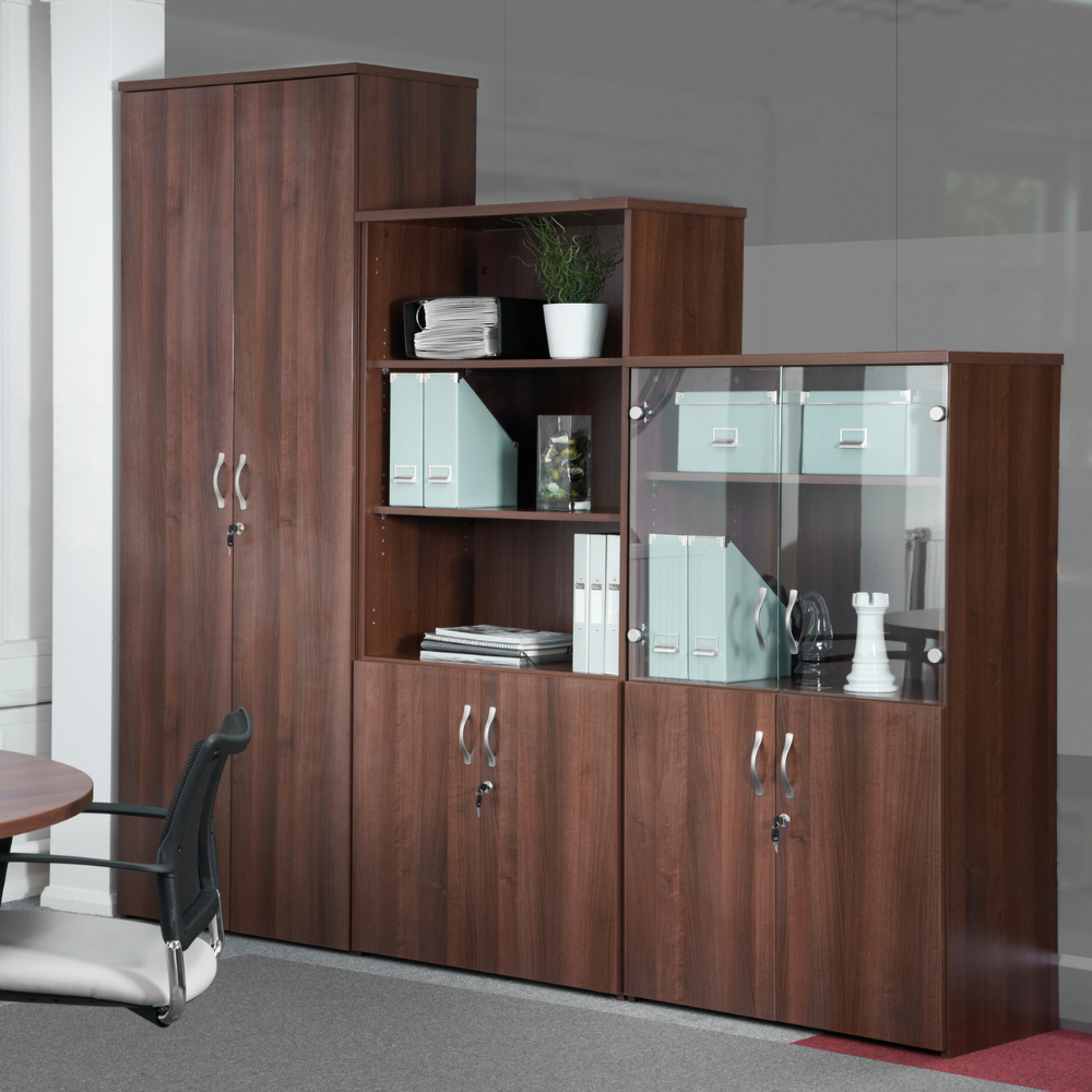 a wooden cabinet with a glass door has binders on it