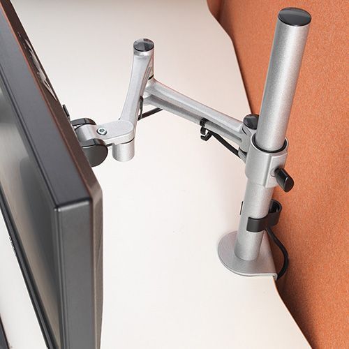 a computer monitor is sitting on a desk with a monitor arm attached to it .