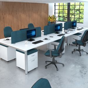 a row of desks with computers and chairs in an office .