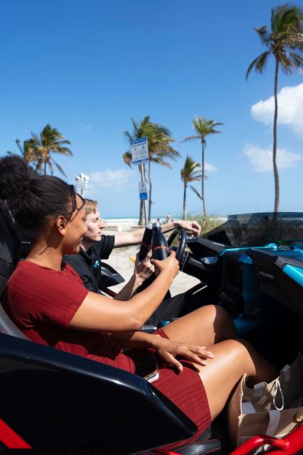 A woman is sitting in a slingshot looking at her phone.