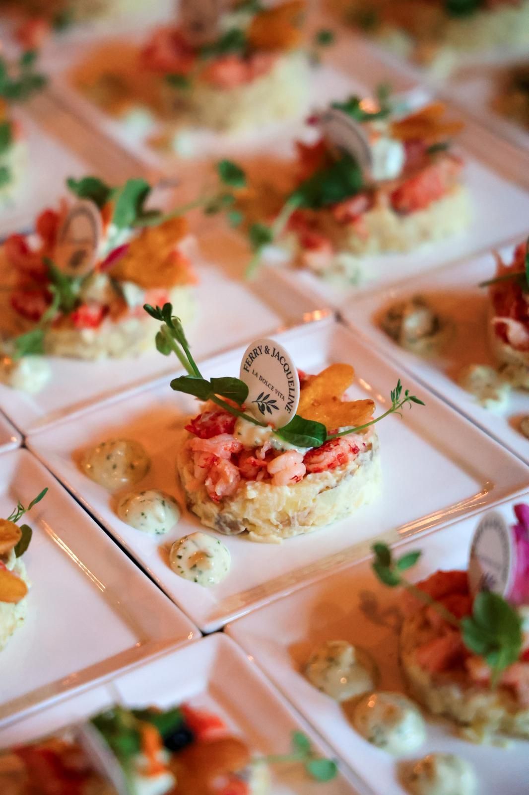 Rij luxe canapés met tartaar en verse kruiden op witte bordjes klaar om te serveren