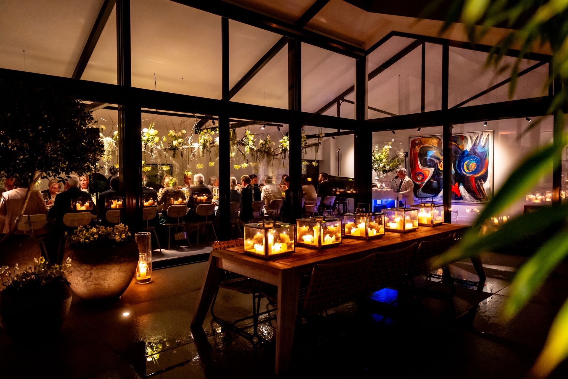 Verlicht buffet in een sfeervolle locatie met glazen wanden tijdens een avondevent