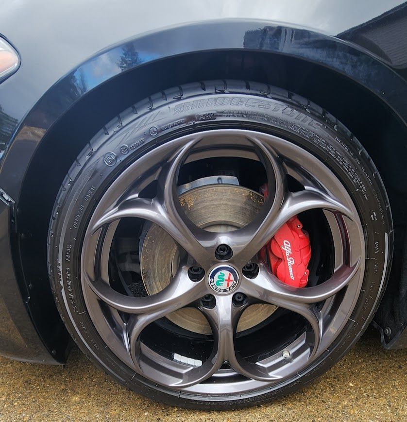 A close up of a car wheel with a red brembo brake
