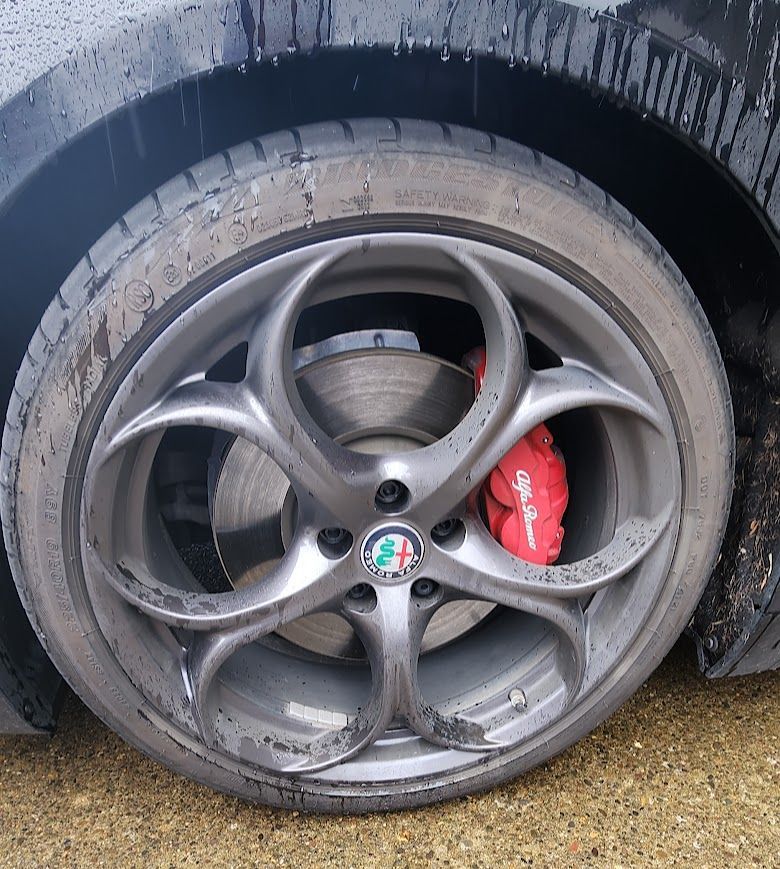 A close up of a car wheel with a red brake pad