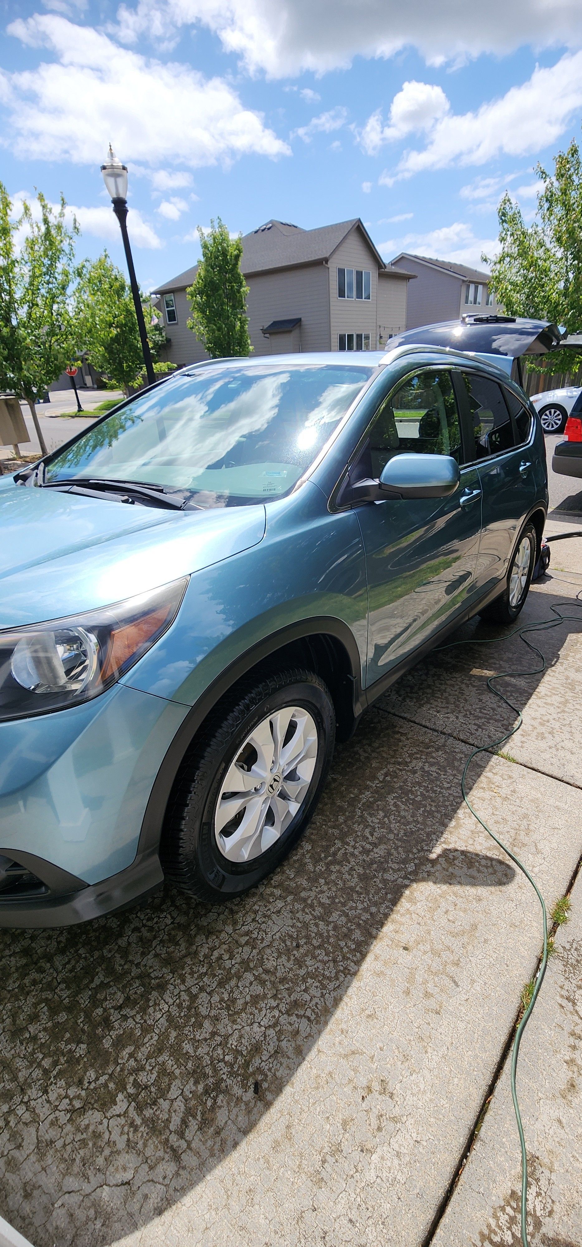 A blue car is parked on the side of the road.