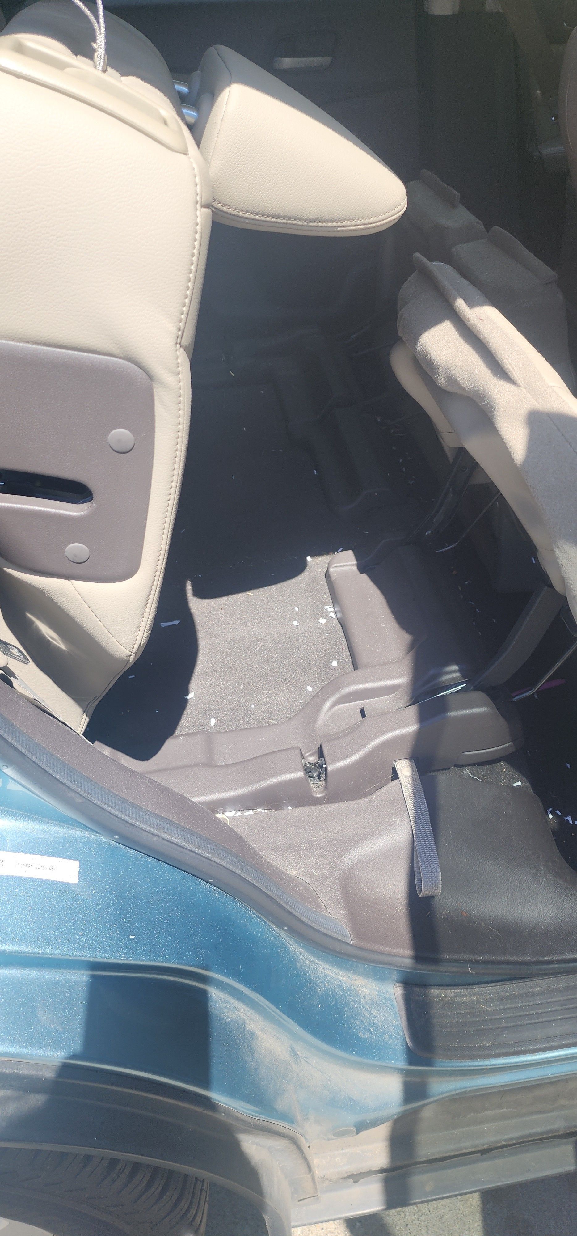 The back seat of a car is empty and dirty.
