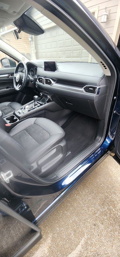 The interior of a blue car is shown with the door open.