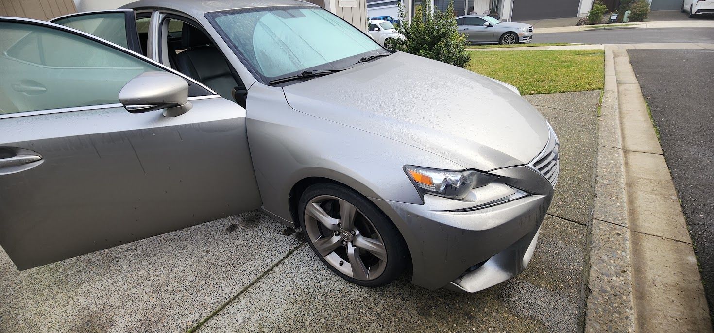 A silver car is parked on the side of the road.