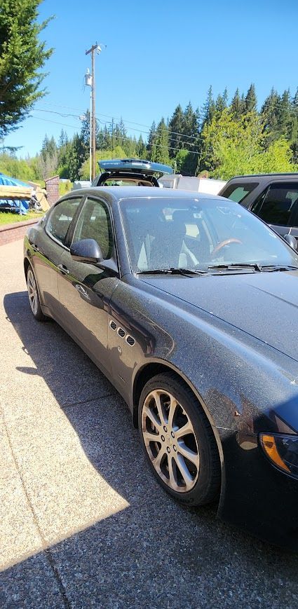 A black car is parked on the side of the road.