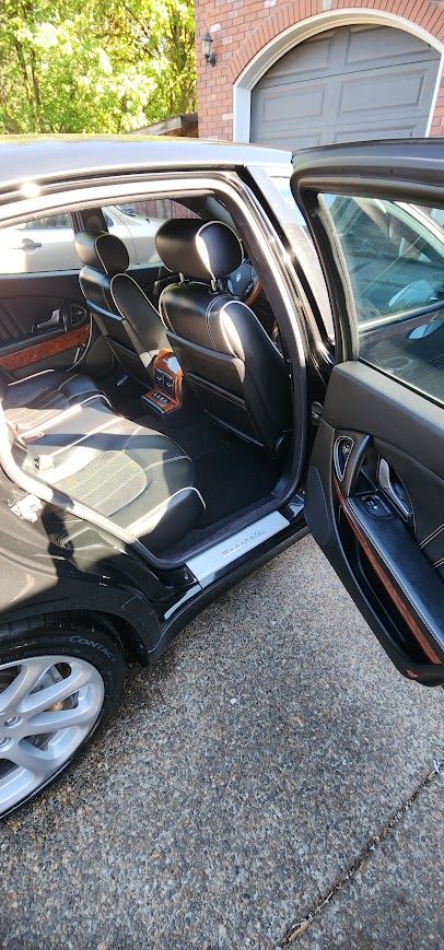 The inside of a black car with the door open.