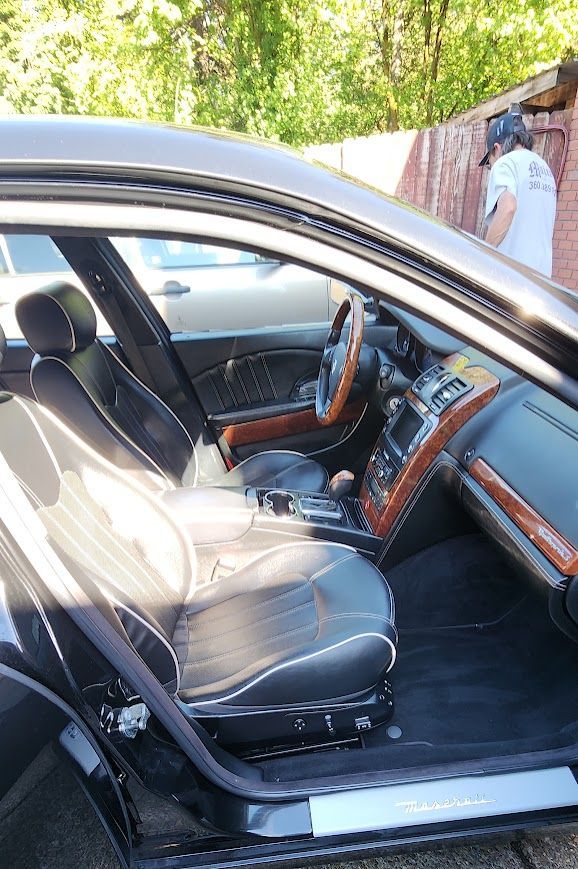 The inside of a black car with the door open.