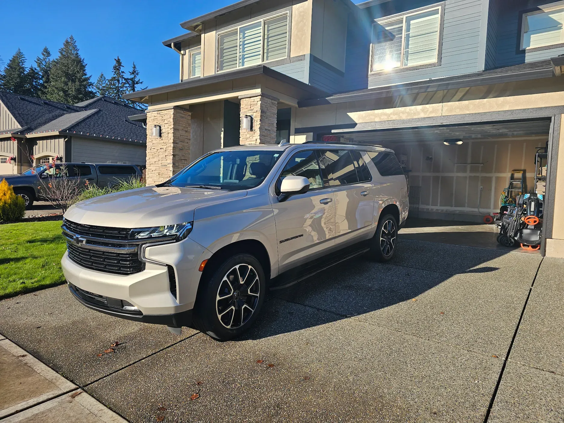 A silver suv is parked in front of a house.