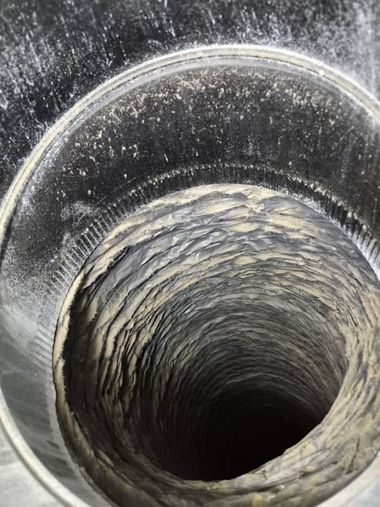 Close-up of a dark, narrow cylindrical tunnel with rough, textured inner walls and a circular opening.