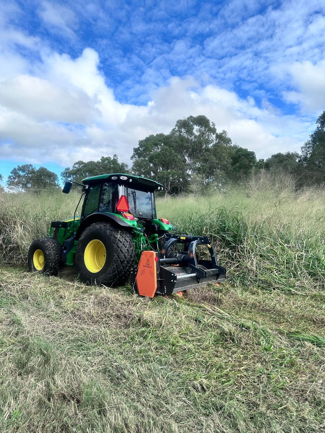 A Tractor Is Parked In Front Of A Pile Of Wood Chips — Branch Manager Tree Services Coolum Beach In Coolum Beach, QLD